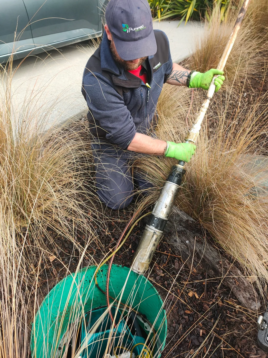Pumped Waste technician servicing equipment beside a septic tank